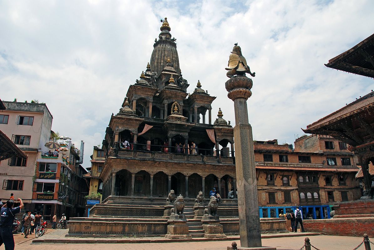 Kathmandu Patan Durbar Square 12 Krishna Mandir And Garuda Column Garuda kneels with folded arms on top of the column facing the Krishna Mandir in Patan�s Durbar Square. Krishna Mandir (1637) is an Indian style stone temple with a shikhara-style spire on top.